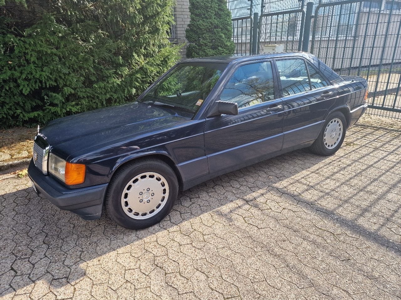 Restaurierter blauer Mercedes-Benz W201 mit markierten Prüfbereichen